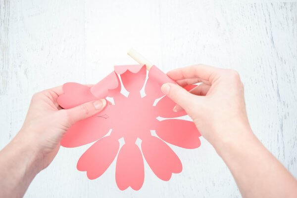 Abbi Kirsten's hand gently bend and curl a paper peony center. 