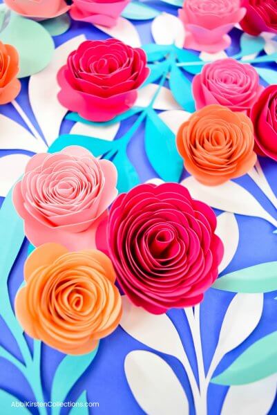 Small bouquets of pink, red, and orange paper rosette flowers with paper stems.