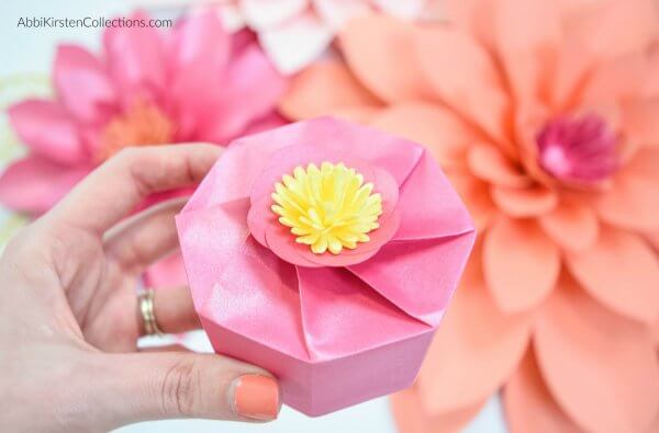 A small pink gift box with a yellow flower on top is a great homemade gift or favor box. You can learn to make these paper boxes with my free template. 