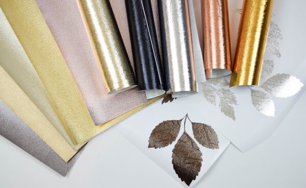 A display of a variety of Cricut-brand metallic textured vinyl, used to make elegant coffee-colored leaves on white pumpkins. 