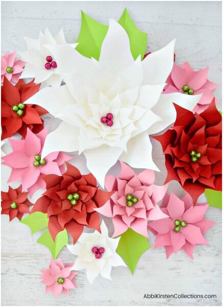 How to make your own giant paper poinsettia flowers for Christmas holiday decor. Download paper poinsettia printable PDF templates and SVG cut files here and follow the step by step tutorial!