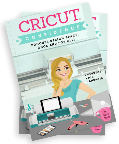 A turquoise book titled Cricut Confidence with a cartoon image of Abbi Kirsten on the cover. 
