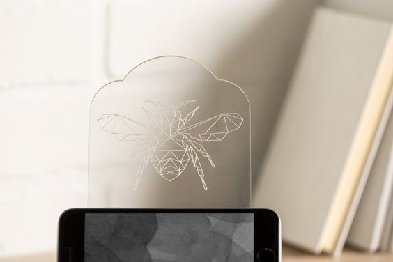 A geometric engraving of a bee on clear plastic. You can learn which blade to use to make engravings with your Cricut machine. 