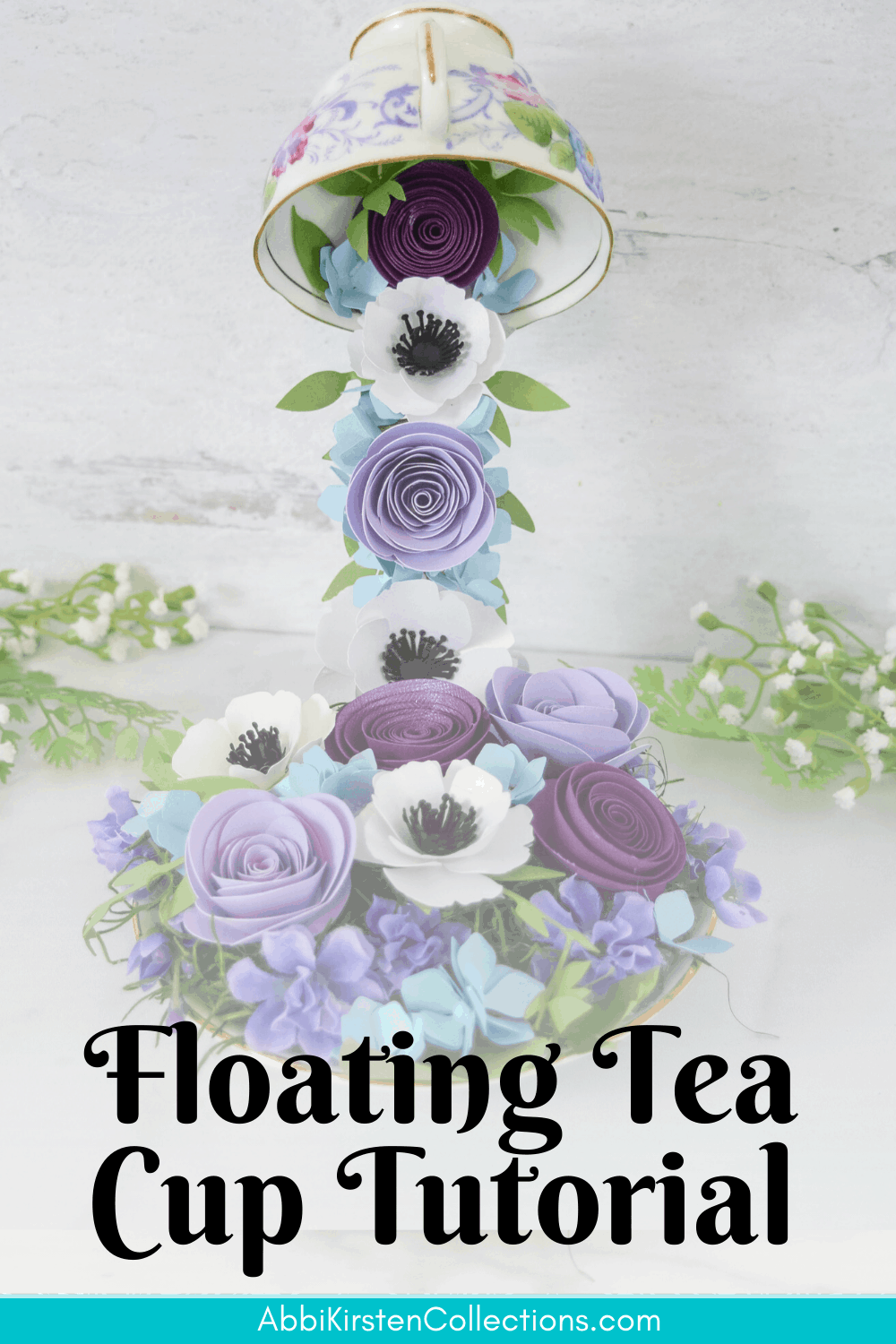 A floating tea cup with a stream of purple, blue, and white cascading paper flowers. Text imposed over the image says "floating tea cup tutorial - abbikirstencollections.com"