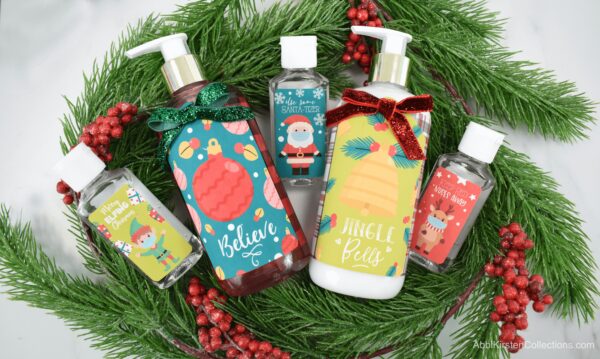 On top of a green wreath with red cranberries lay examples of soap and hand sanitizer bottles with personalized Christmas stickers. These make a great last minute Christmas gift. 
