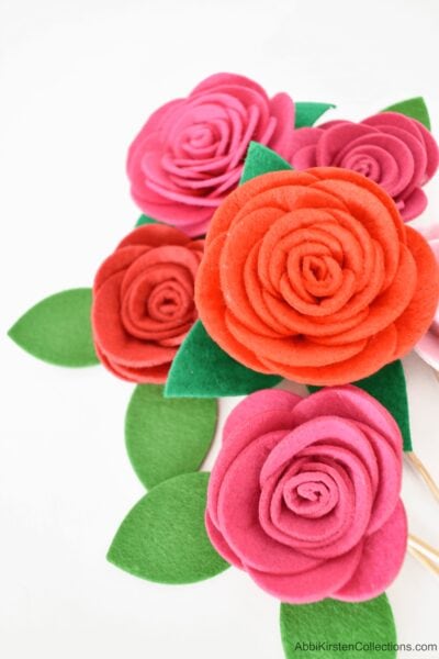 Felt roses in shades of red and pink fill the image. Green felt leaves add realism to this Cricut felt craft. 