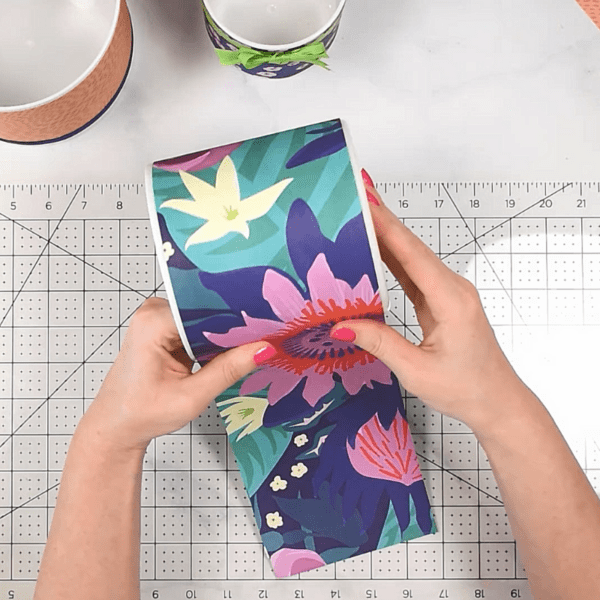Covering vases with patterned wrapping paper on a ruled workstation. 