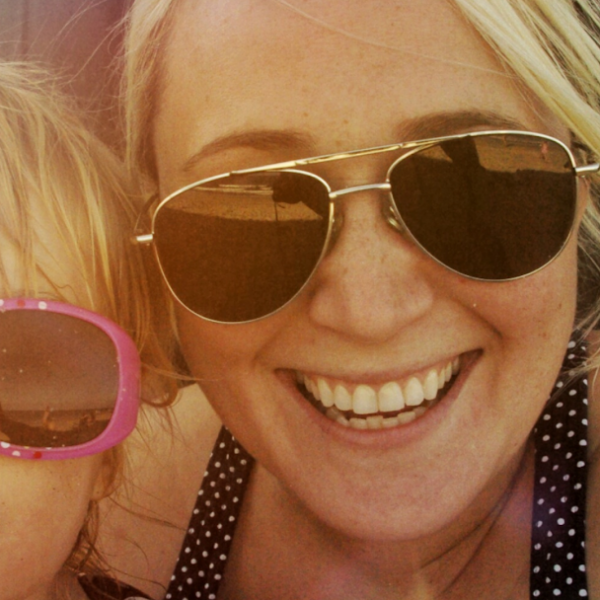 Sam is wearing sunglasses and smiling next to her child's face. She found the Cricut Workshop for Beginners helpful. 