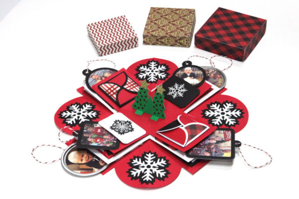 A red, black and white Christmas explosion gift box with green Christmas trees at the center surrounded by mini photos. 
