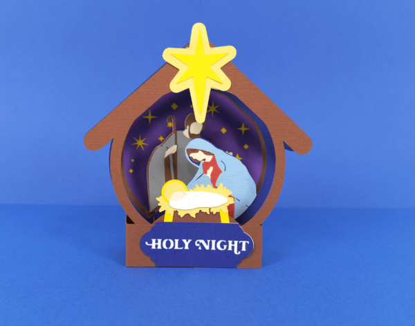 Nativity scene pop up card for Christmas handmade with cardstock. Card is shown on a navy blue background. 