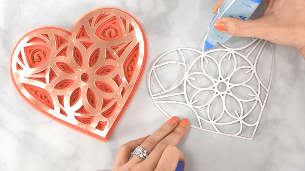 Glue being applied to one layer of a heart mandala.