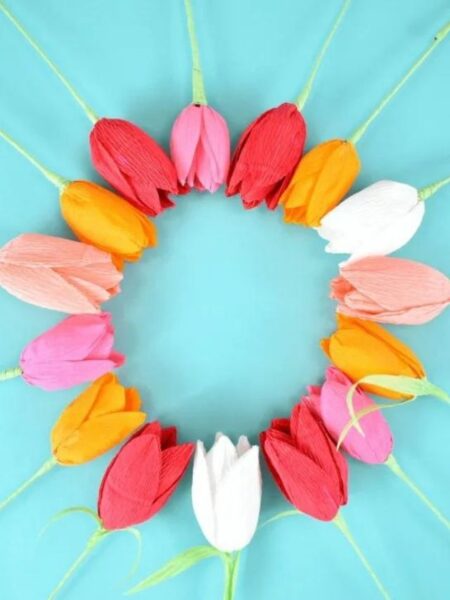 colorful crepe paper tulips arranged in a circle against a blue background