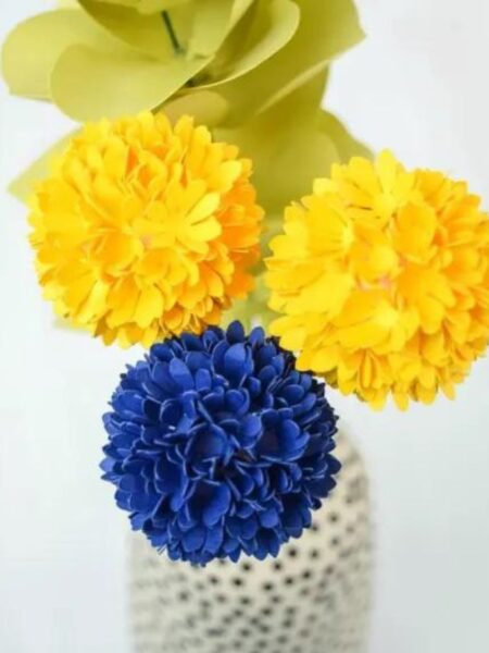 Paper Billy Buttons in blue and yellow, in a black and white polka dot vase.