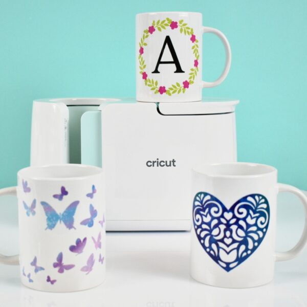 Cricut Mug Press wit colorful butterfly and heart mug designs. 