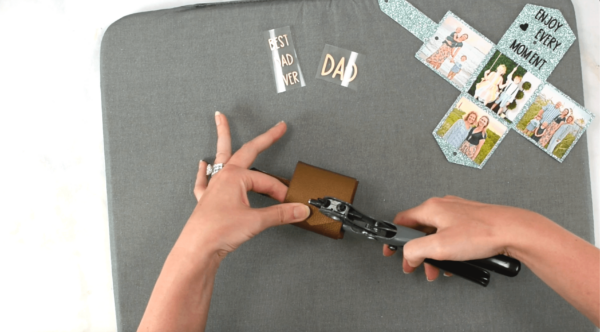 Punching holes in bronze faux leather for snaps and keychains with a black and grey hole puncher. 