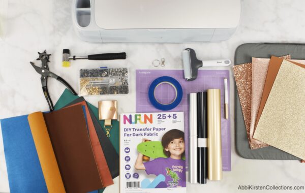 A workstation with all the tools and supplies needed to create personalized faux leather photo keychains. 