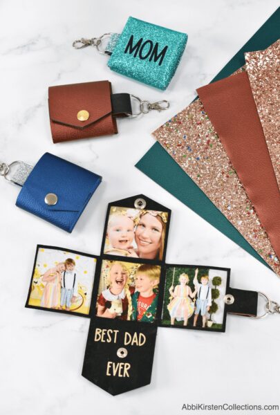 Multiple DIY faux leather photo keychains in different colors and with varying text next to colorful sheets of faux leather.  
