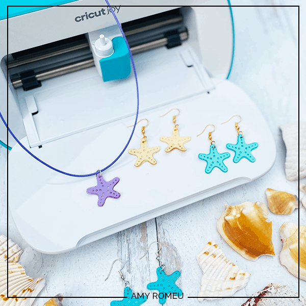 A starfish necklace and earrings are showcased on an open Cricut Joy. Shells sit on the edges of the photo. 