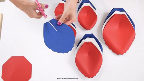 The image shows giant paper flower petals in red white and blue for a july 4th paper flower decoration.