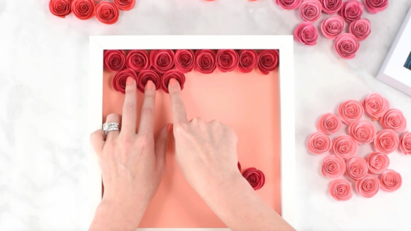 How to added rolled paper flowers to a shadow box.