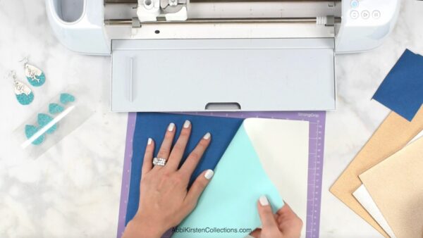 Placing faux leather on the strong grip cricut mat. 