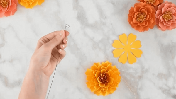 Stemming a paper marigold flower. 