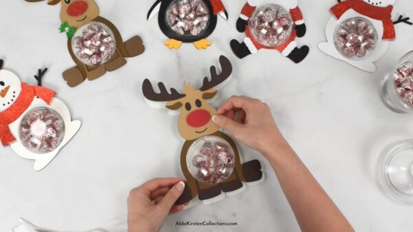 Assembling the reindeer paper craft project for candy. 