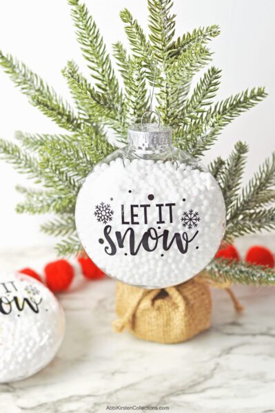 Create fillable Christmas ornaments with snow using this easy DIY tutorial. Download the free Let it Snow SVG file to use with Cricut.