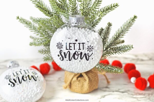 Create fillable Christmas ornaments with this easy DIY tutorial. Download the free Let it Snow SVG file to use with Cricut.
