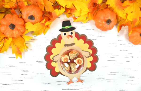 DIY turkey candy holder. Image shows a turkey svg made from paper with candy in a plastic ornament ball. 