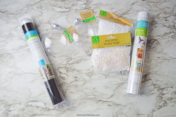 Images shows the supplies to make DIY christmas fillable ornaments. 