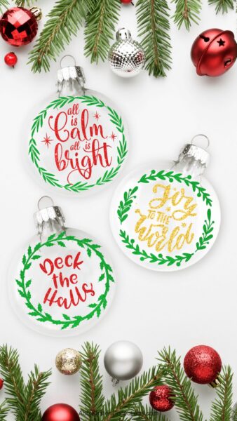 The images show a set of three Christmas ornaments on a desk with the phrases, all is calm, all is bright, joy to the world and deck the halls. 