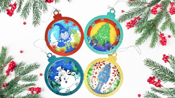 3D layered paper ornaments made with cardstock paper and Cricut machine. Images shows 4 paper ornaments with a santa, Christmas tree, snowman and nutcracker design. 