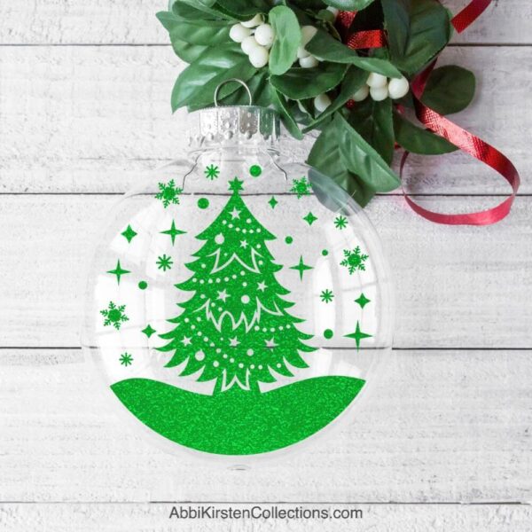 Clear plastic ornament with a Christmas Tree SVG design floating in the center. 