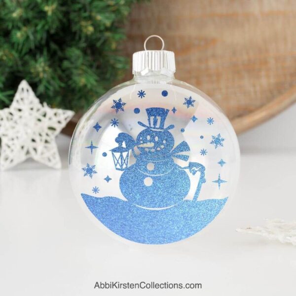 Snowman ornament in blue on a desk. 
