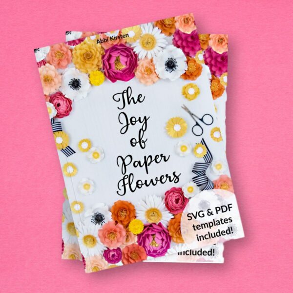 Two copies of a book are stacked on top of each other. The title is "The Joy of Paper Flowers" by Abbi Kirsten.