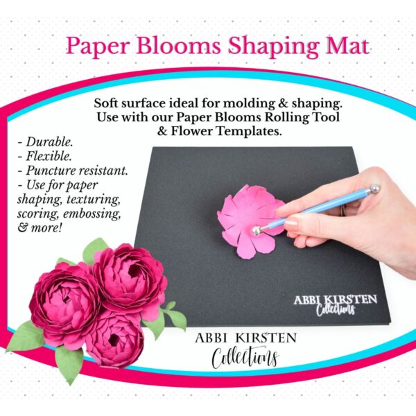 A picture of a mat and Abbi Kirsten's hand using a shaping tool on a pink paper petal. Additional paper flowers are in the corner. The picture is an advertisement for Abbi Kirsten's "Paper Blooms Shaping Mat."
