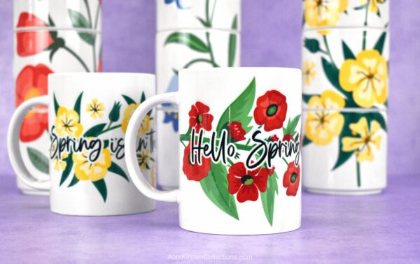 The image shows sublimation on mugs with a bright poppy floral design that says, "Hello Spring.' All the mug designs are free to download. 