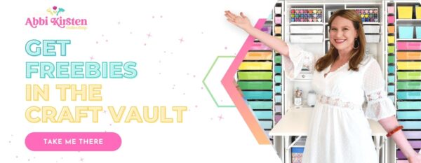 A large graphic shows Abbi Kirsten smiling in a white dress in front of her colorful craft supplies. She is indicating to the text on the left side of the graphic, which says, "Abbi Kirsten Collections Get Freebies in the Craft Vault, Take Me There."