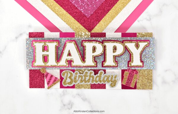 The image shows a handmade happy birthday card. These layered Cricut cards are easy for beginners. 