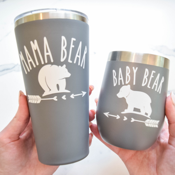 The image shows two cuts with the design Mama Bear and Baby Bear in white vinyl on the front. Get the free SVG on Abbi Kirsten Collections.