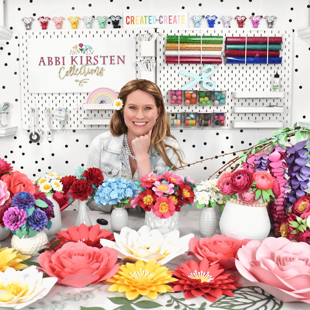 Abbi Kirsten with lots of paper flowers in desk