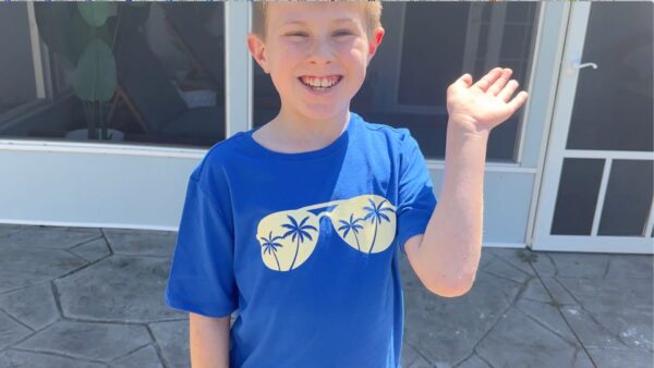 Young boy wearing a blue t-shirt with sunglasses that were added on with UV iron on vinyl