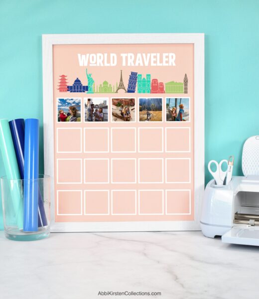 The image shows a world traveler picture display on a pink matboard with a white frame. This project was created using a Cricut machine, vinyl and print then cut sticker vinyl.