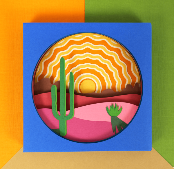Colorful 3D layered paper shadow box made with Cricut. The shadow box scene shows a sunrise in the desert with a cactus. 