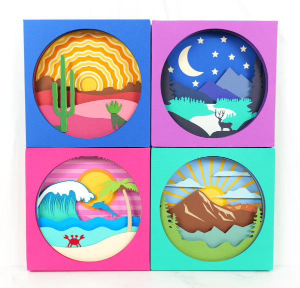 Set of 4 landscape shadow box scenes showing a beach, a mountain range, a mountain and river and a desert sunrise. 