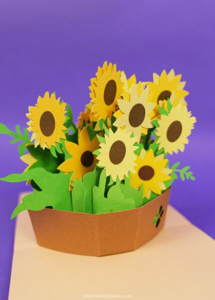 Yellow sunflower basket pop up card made from cardstock with Cricut on a purple background. 