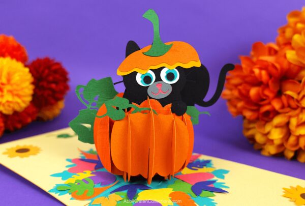 Pop up pumpkin card with a black cat made from cardstock paper with Cricut. 