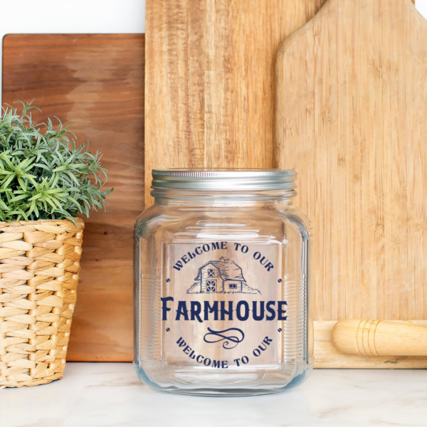 Welcome to our farmhouse SVG file on a mason jar sitting on a kitchen counter with cutting boards. 