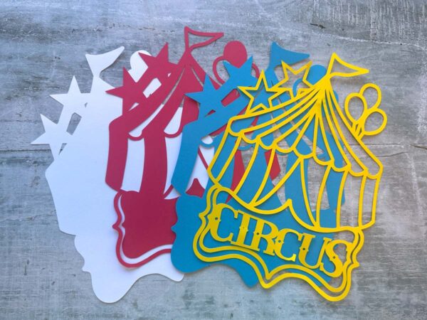 Four circus tent cutouts in white, red, blue, and yellow with text Circus.